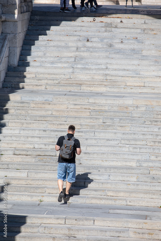 people walking by stone stairs with backpack