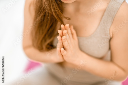 Girl does yoga. Young woman practices asanas on a beige one-ton background.