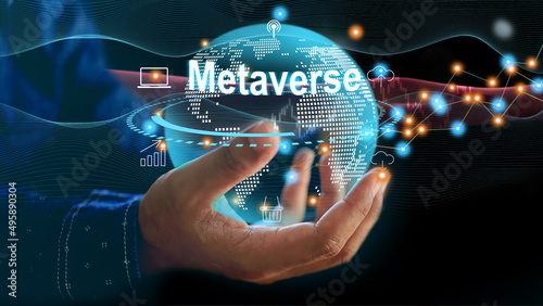 Man using virtual metaverse to manage data and analyze marketing online information to plan for future investment in a virtual and metaverse market. Globe in businessman hand.