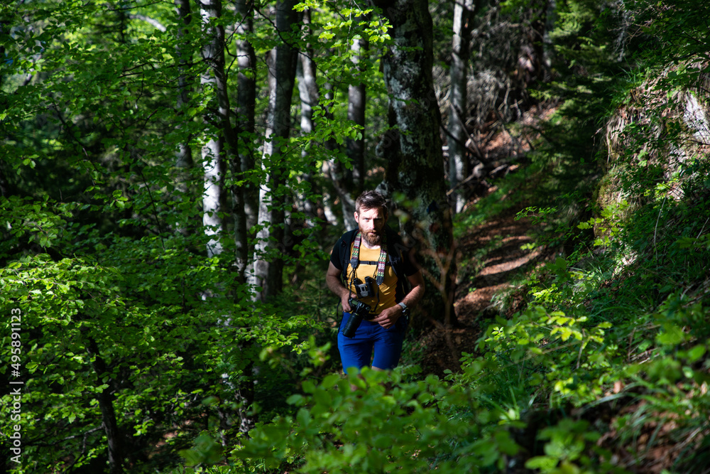 man using binoculars while trekking in nature man using binoculars while trekking in nature