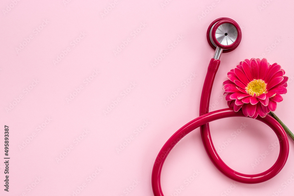 Fototapeta premium Breast cancer awareness concept with red flower and stethoscope