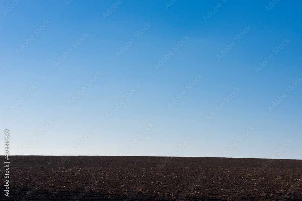 Ploughed field and blue sky as background. Ploughed field and blue sky as background.