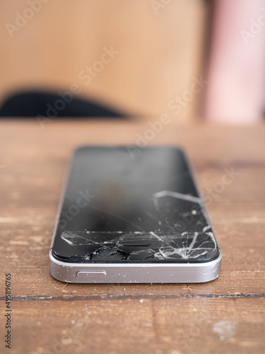 Smartphone with a broken screen on a wooden table