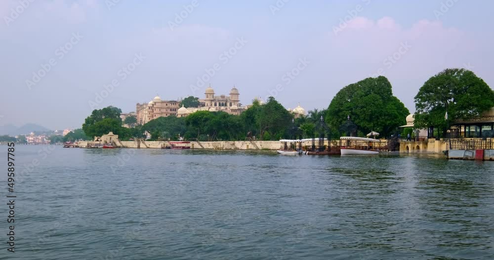 Udaipur City Palace view from moving boat on lake Pichola. Luxury palace is Rajput architecture of Mewar dynasty rulers of Rajasthan and famous tourist Indian landmark. Incredible India heritage. Udaipur City Palace view from moving boat on lake Pichola. Luxury palace is Rajput architecture of Mewar dynasty rulers of Rajasthan and famous tourist Indian landmark. Incredible India heritage.