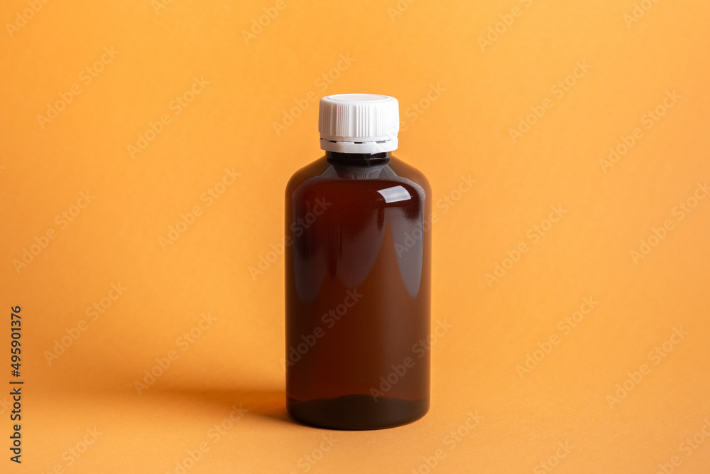 Clean brown jar for cosmetics on an orange background