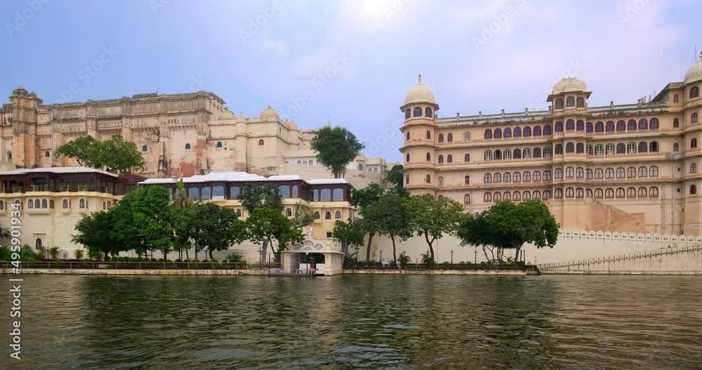 Udaipur City Palace panoramic view from boat on lake Pichola. White palace is Rajput architecture of Mewar dynasty rulers of Rajasthan and famous tourist Indian landmark. Incredible India heritage Udaipur City Palace panoramic view from boat on lake Pichola. White palace is Rajput architecture of Mewar dynasty rulers of Rajasthan and famous tourist Indian landmark. Incredible India heritage