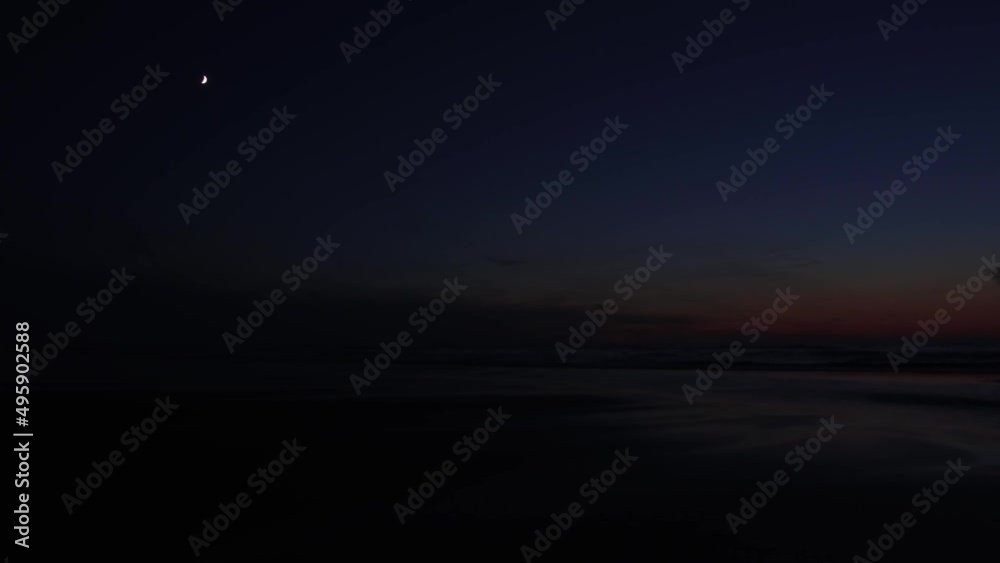 Nautical twilight along the North Sea coast with moon in the sky in Ostend, Belgium. Nautical twilight along the North Sea coast with moon in the sky in Ostend, Belgium.