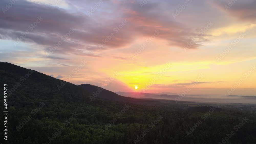 Aerial view of green pine forest with dark spruce trees covering mountain hills at sunset. Nothern woodland scenery from above Aerial view of green pine forest with dark spruce trees covering mountain hills at sunset. Nothern woodland scenery from above