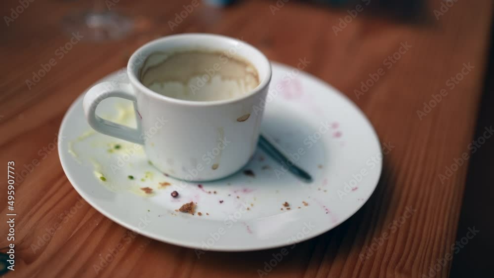 An empty cup of coffee leftovers on table after lunch An empty cup of coffee leftovers on table after lunch