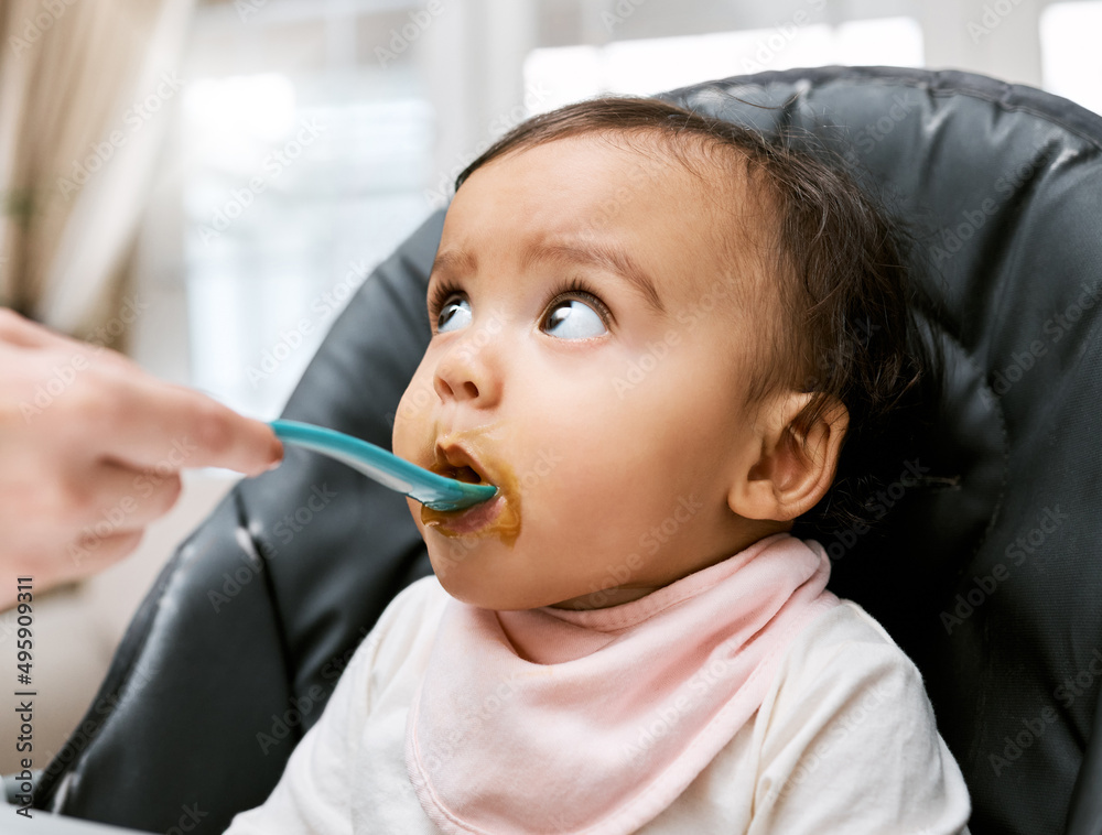 This tastes a little different than what Im used to. Shot of a mother feeding her adorable baby girl. This tastes a little different than what Im used to. Shot of a mother feeding her adorable baby girl.