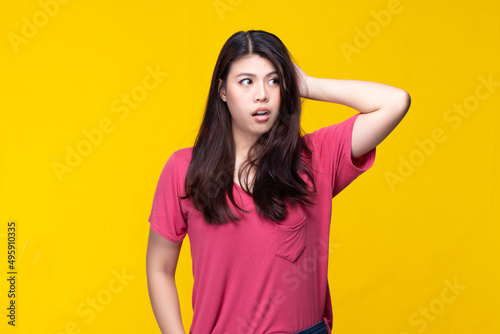 Image of feeling excited, shock, surprise and happy. Young asian woman standing on yellow background. Female face expressions and emotions body language concept.