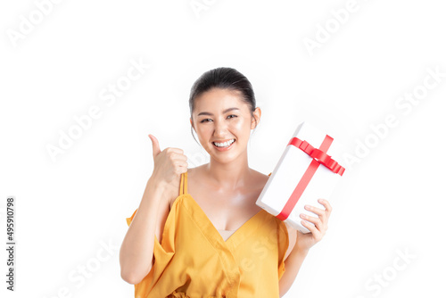Asian woman holding gift box in christmas  new year  valentine day  birthday celebration concept. Portrait of smiling happy pretty girl holding gift box and showing thumbs up isolated on white