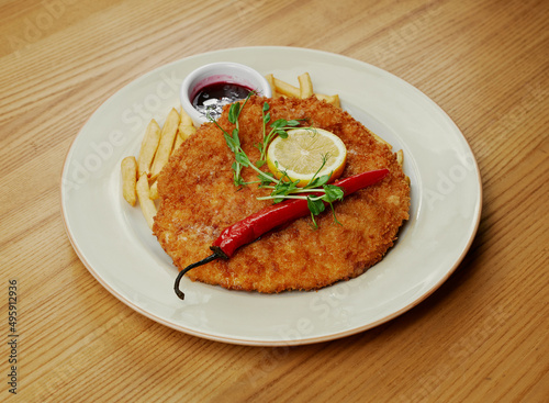 schnitzel with french fries, sauce and pepper