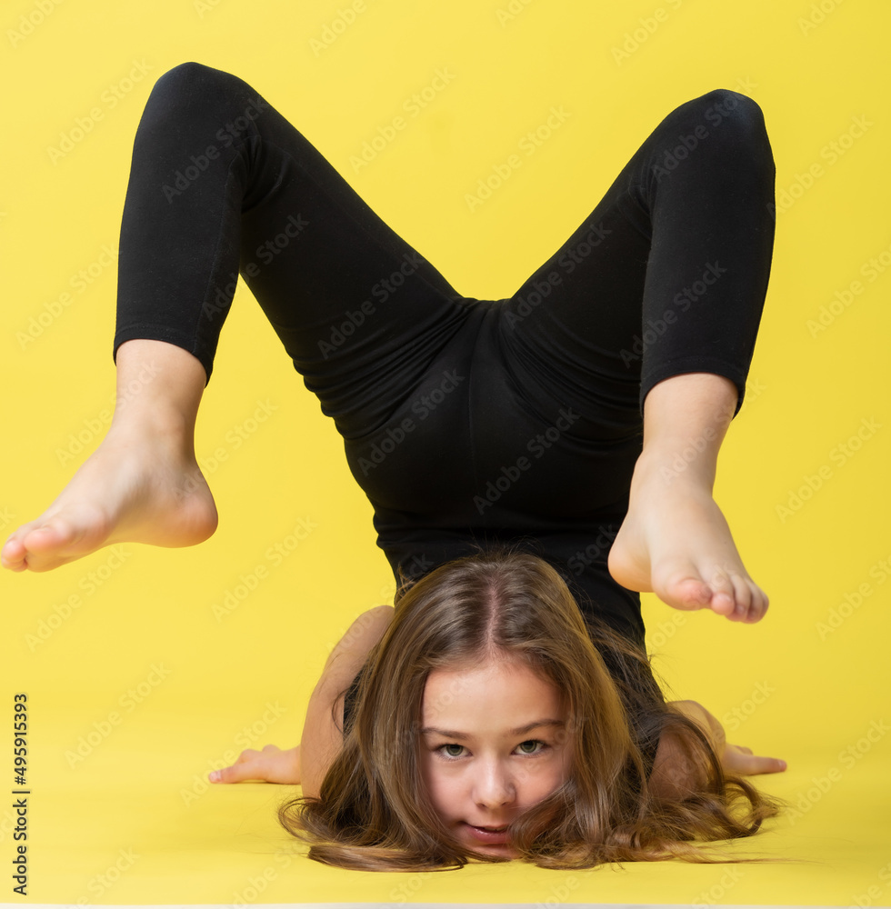 girl gymnast studio. little gymnast trains, shows a gymnastic element ...