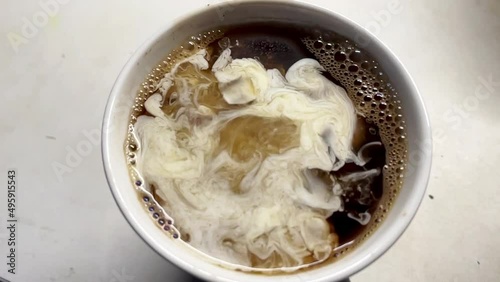 Pouring milk into the coffee cup, morning ritual