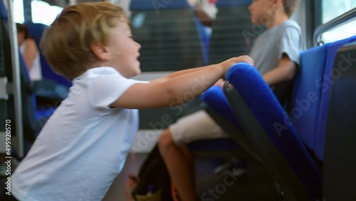 MIschievous children traveling by train kids not behaving playing with seats photo