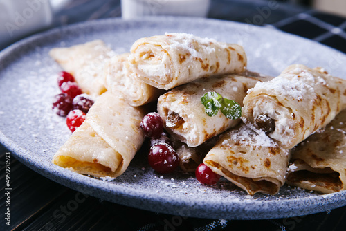 Pancakes with cottage cheese, cranberries and honey on a gray plate