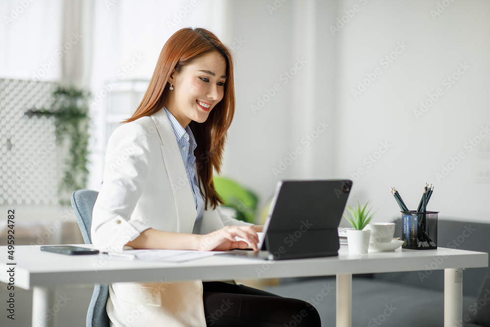 Young Business Asian woman using the tablet for doing math finance on wooden desk in office, analysis, seo, data, analyst, asian, financial, tax, accounting, Report financial document concept Young Business Asian woman using the tablet for doing math finance on wooden desk in office, analysis, seo, data, analyst, asian, financial, tax, accounting, Report financial document concept
