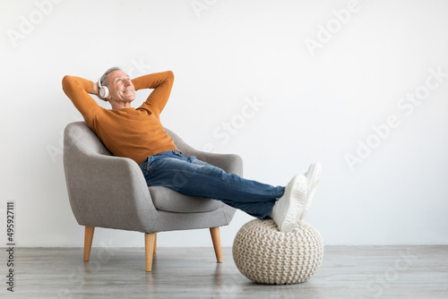 Calm mature man having rest at home listening to music Fototapeta