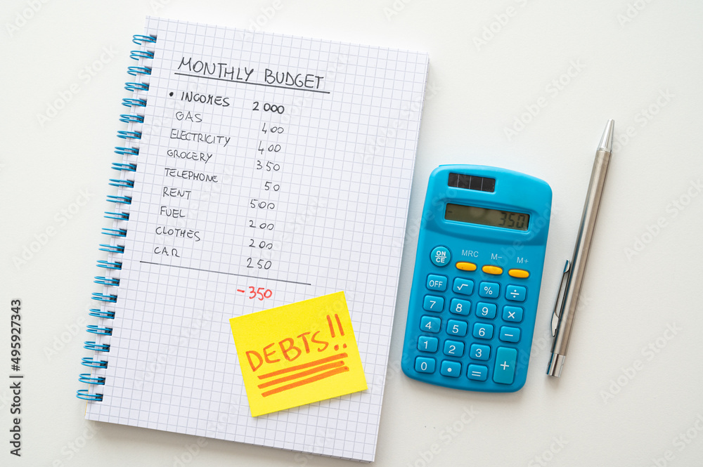 Squared notebook, with monthly budget, calculations, yellow card with the text Squared notebook, with monthly budget, calculations, yellow card with the text