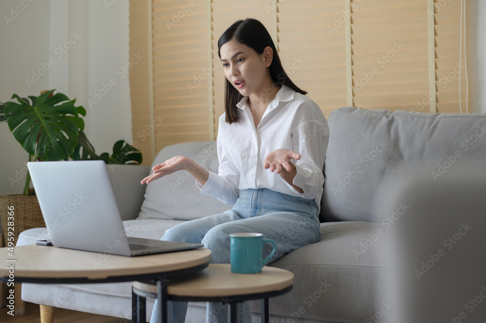 Beautiful young woman making video conference call via computer at home , business technology concept Beautiful young woman making video conference call via computer at home , business technology concept