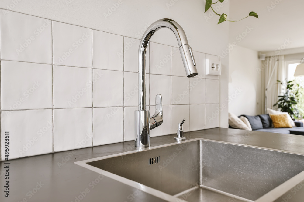 Metal tap and sink in modern kitchen