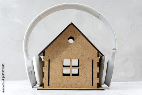 Tableau sur toile Wireless headphones on a toy wooden house close-up