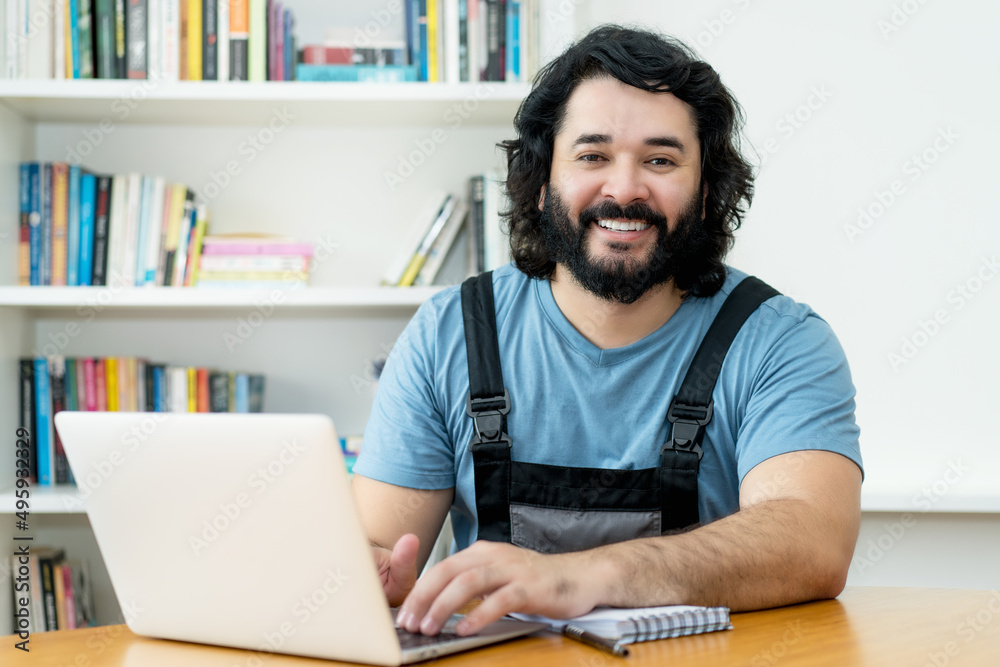 Laughing handyman with beard working at computer Laughing handyman with beard working at computer