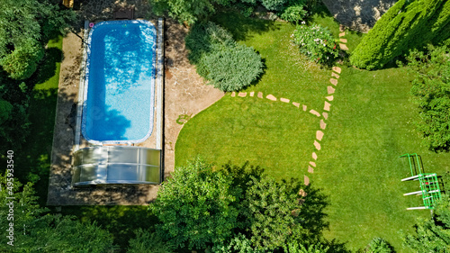 Swimming pool in beautiful garden aerial top view from above 