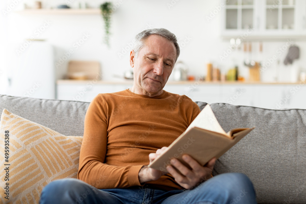 Portrait of mature man reading book at home Portrait of mature man reading book at home