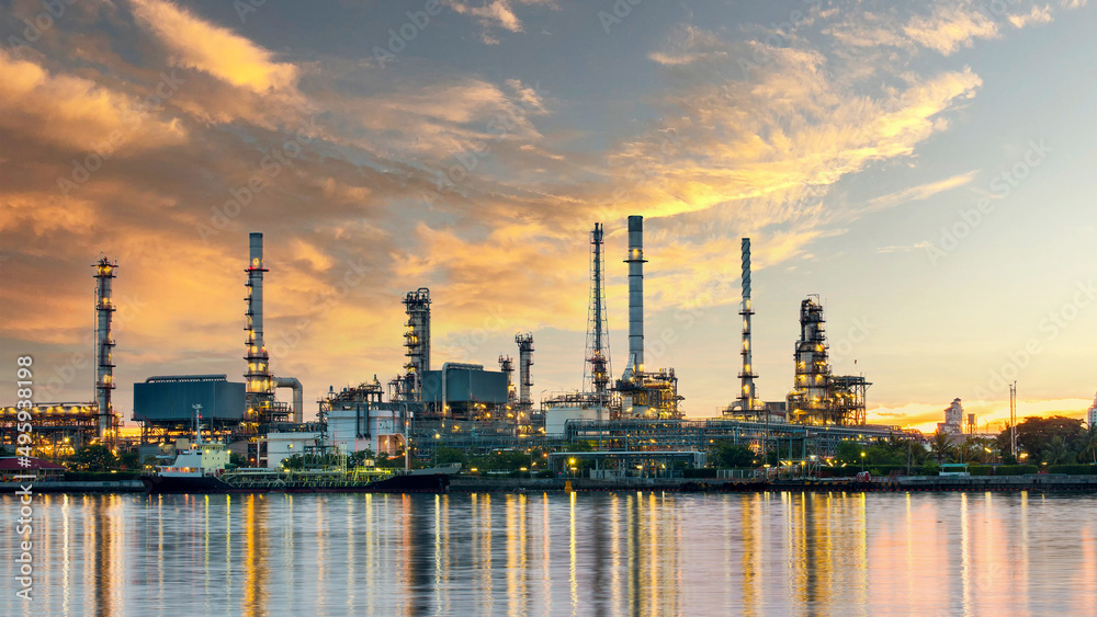 Obraz premium Oil and gas refinery plant area at sunrise near sea port or river