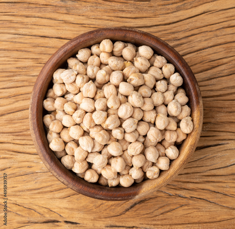 Raw chickpeas on a bowl over wooden table