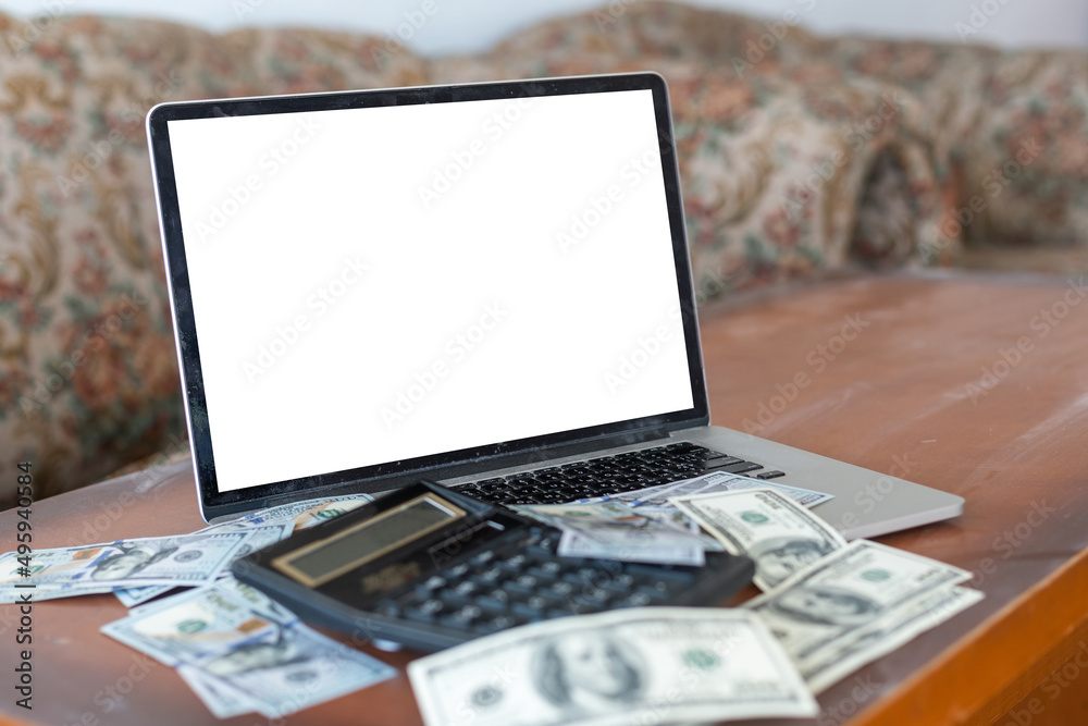 Finance concept: The United States hundred-dollar bills, calculator, bills, laptop on the table Finance concept: The United States hundred-dollar bills, calculator, bills, laptop on the table