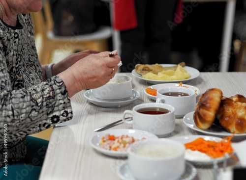 An elderly woman sits at a table in the dining room of the sanatorium and eats. Healthy delicious food.