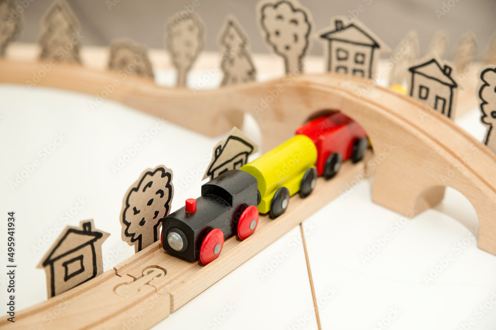 Wooden railway with steam train. Kids toy on wooden floor. Children room theme. Symbolic of careless childhood, dreams, war and easy life. Wooden railway with steam train. Kids toy on wooden floor. Children room theme. Symbolic of careless childhood, dreams, war and easy life.