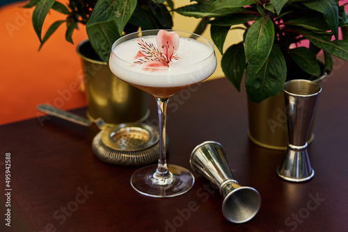 Beautiful cocktail and two flowers on table