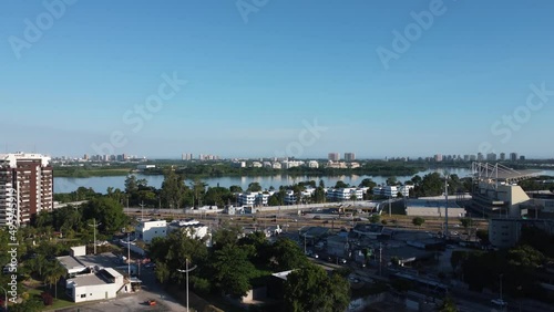 Aerial view of Jacarépaguá Lagoon in Rio de Janeiro, Brazil. Residential buildings and mountains around. Cars on Aberlado Bueno Avenue. Barra da Tijuca in the background. Sunny day. Drone take. photo