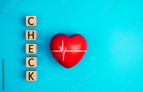 arranging wood block with CHECK message with a red heart, health care check heart. Insurance for your health medical concept.