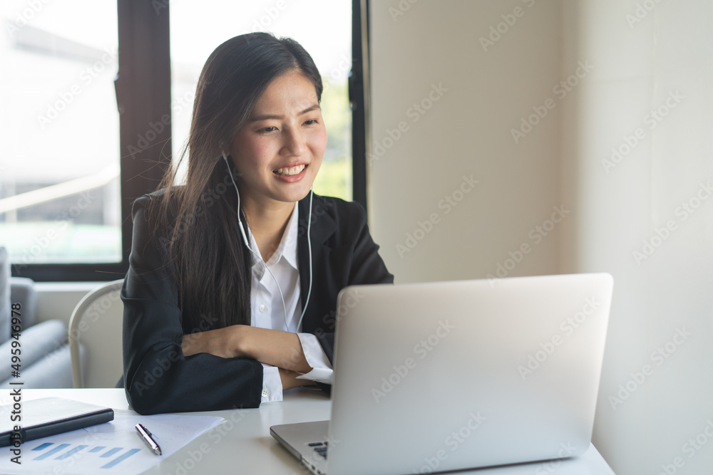 Happy young asian business woman waving hands to greeting partner during making video conference with her team. Happy young asian business woman waving hands to greeting partner during making video conference with her team.