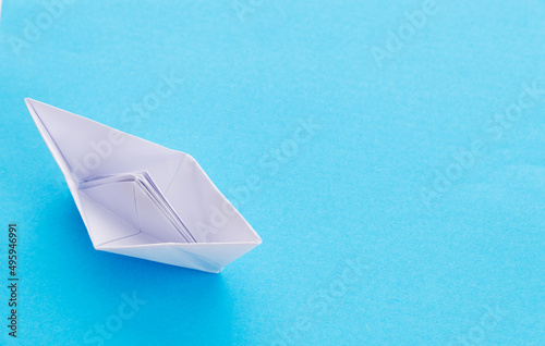 White origami boat on blue background