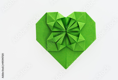 Green origami heart on white background © xy