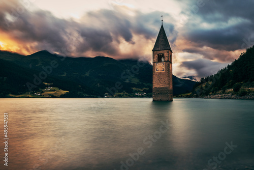 tower bell submersed in the lake at sunset in curon