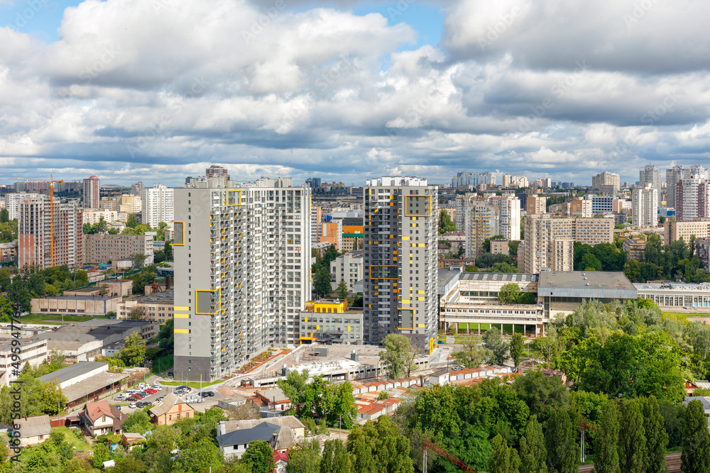 Obraz premium Cityscape from a bird's eye view with a view of the development of the old microdistrict with new high-rise residential buildings.