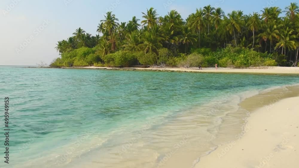 Remote tropical island paradise with shallow lagoon in ocean and thick vegetation of coconut palm trees cocos nucifera Remote tropical island paradise with shallow lagoon in ocean and thick vegetation of coconut palm trees cocos nucifera
