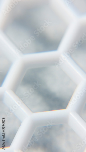 Detalle de cuadrícula de celdas hexagonales en rejilla de plástico blanco