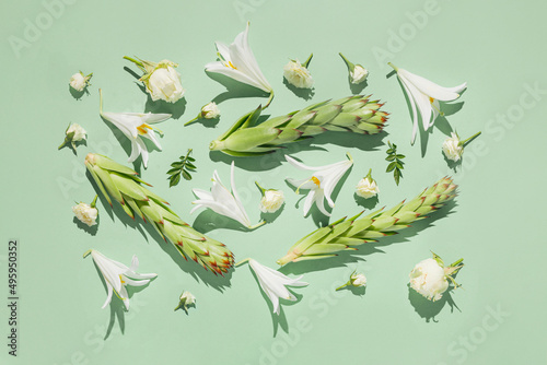 Floral summer composition made of beautiful white lily and rose flowers on pastel sunlit  background with shadows. Nature concept. Top view. Flat lay