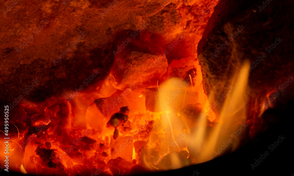Fototapeta premium Flame coals red-hot with heat and tongues of fire