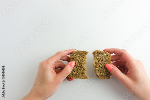 Female hands holding halved slice of homemade sunflower bread