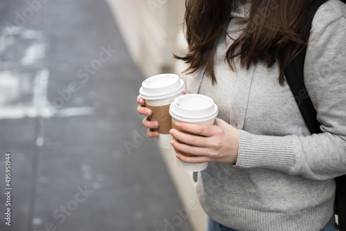 View of a person with two takeaway coffees for sharing with somebody