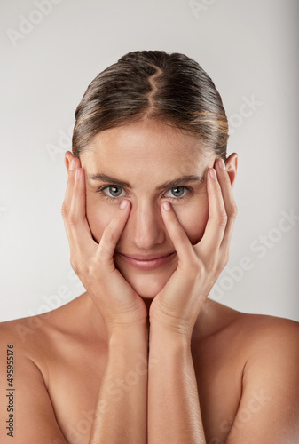 My skin has never felt better. Closeup studio portrait of a beautiful young woman touching her face.